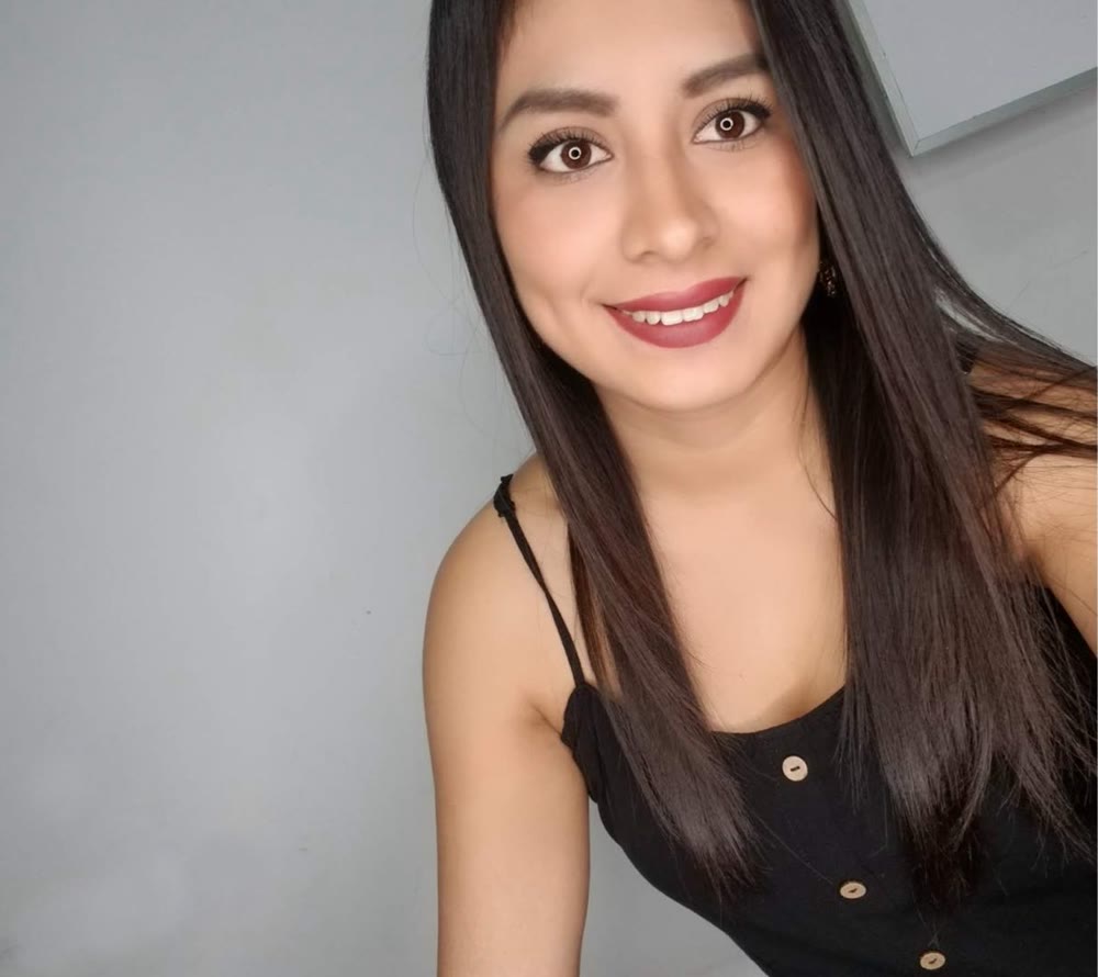 Woman with long dark hair smiling warmly at the camera
